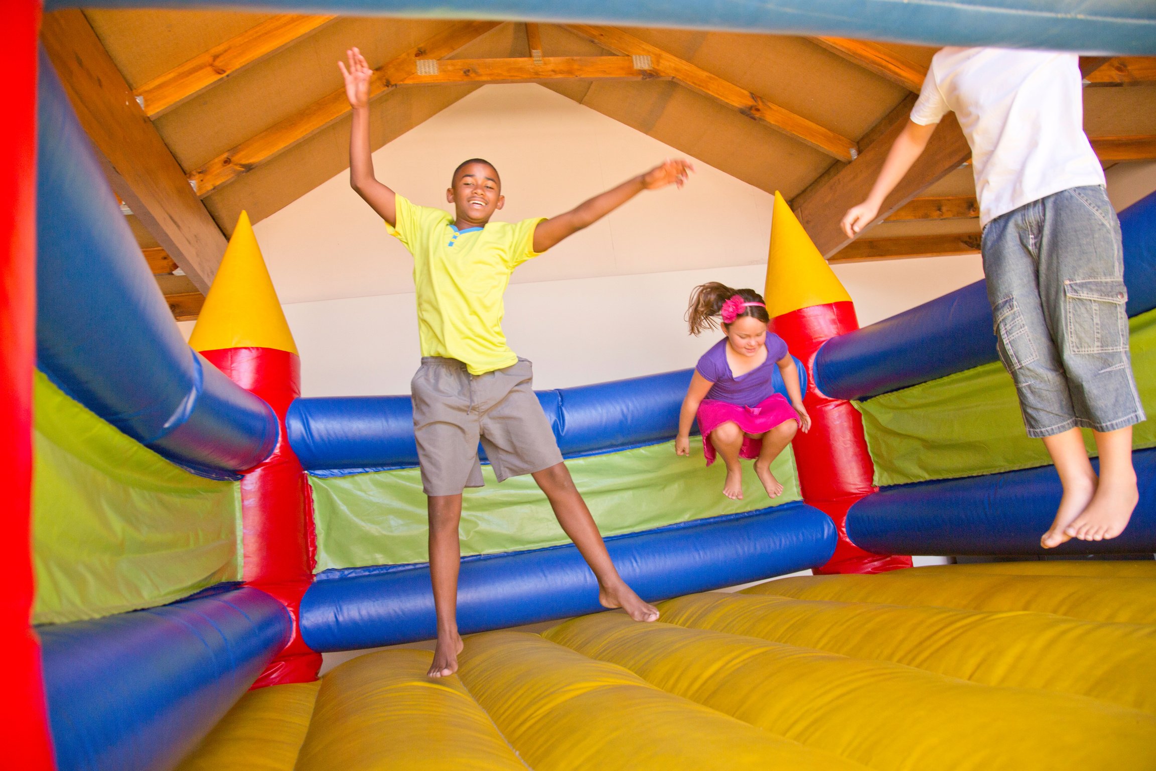 African & white children jumping on a bouncy castle