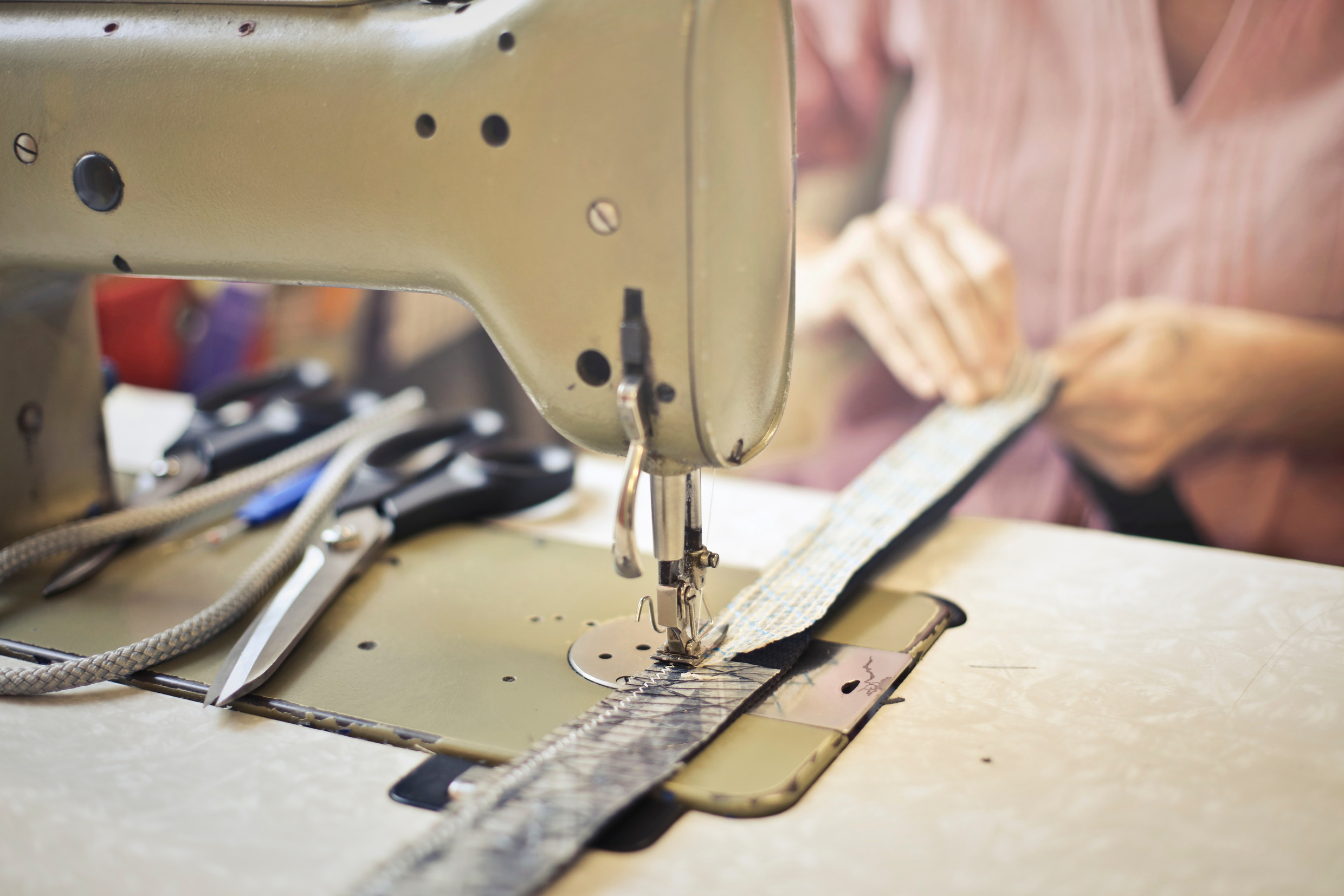 Seamstress stitching clothing item on sewing machine